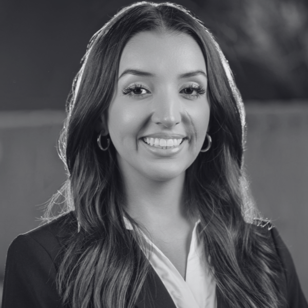 Black and white portrait of a young woman in a suit jacket and white blouse, smiling.